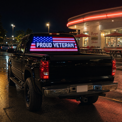 PROUD VETERAN design lit on a pickup truck rear window outside a diner at night